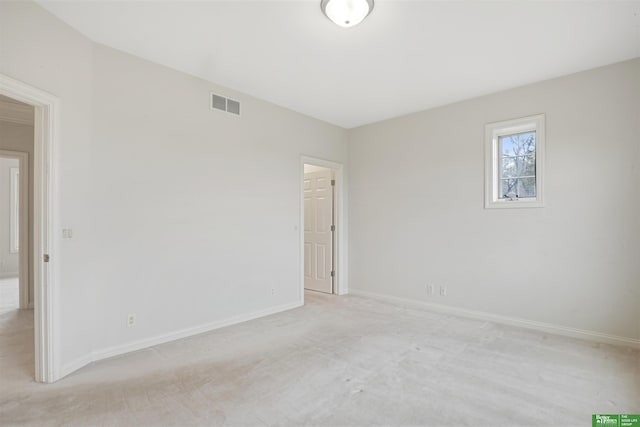 spare room featuring light colored carpet