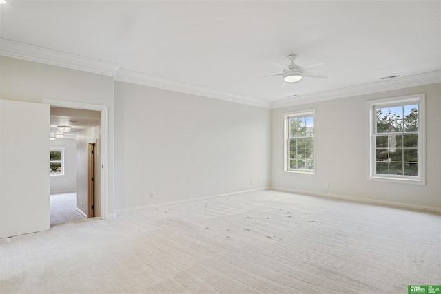 carpeted empty room featuring ceiling fan, a healthy amount of sunlight, and crown molding