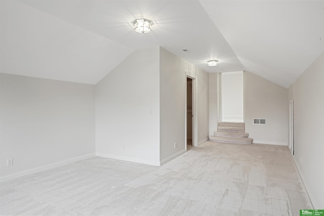 additional living space with light colored carpet and lofted ceiling