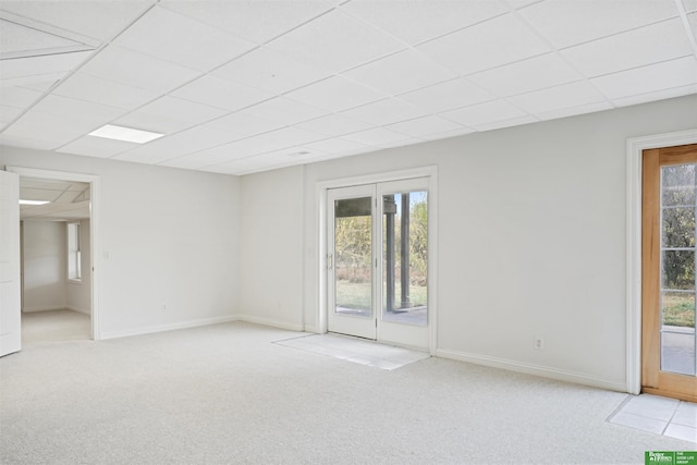 carpeted spare room with a drop ceiling