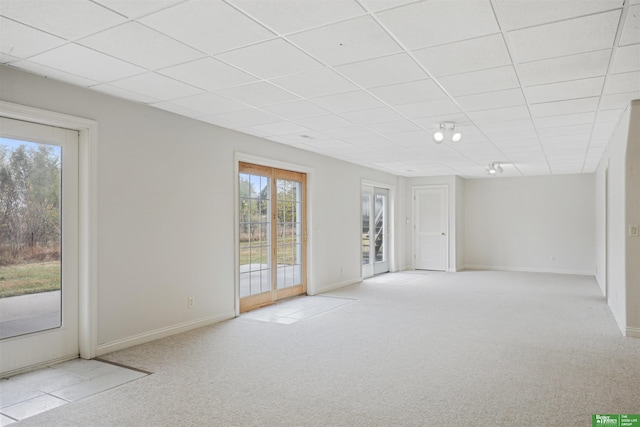 spare room with light colored carpet and a drop ceiling