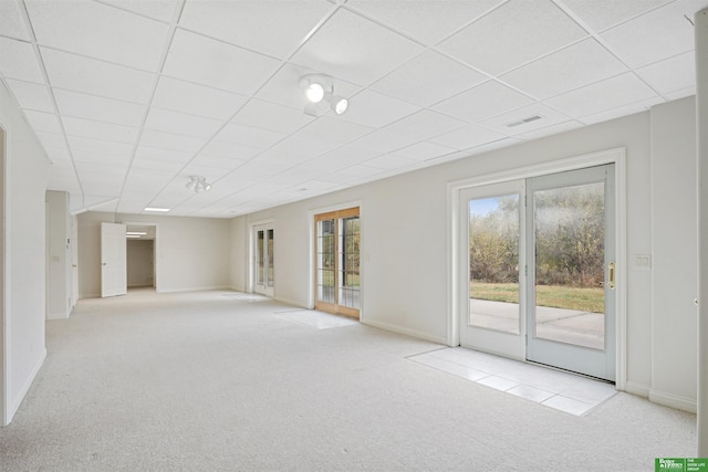 carpeted spare room with a drop ceiling