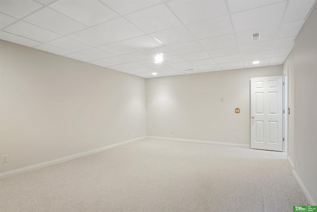 spare room with a drop ceiling and light colored carpet