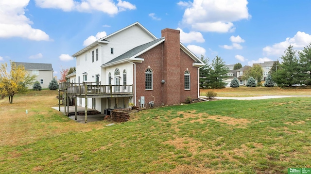 rear view of property with a lawn, cooling unit, a patio, and a deck