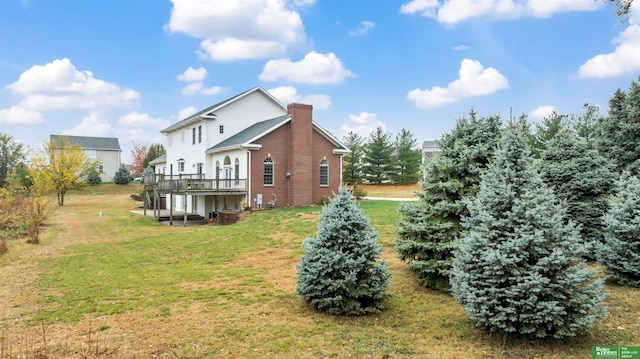 rear view of property with a lawn and a deck