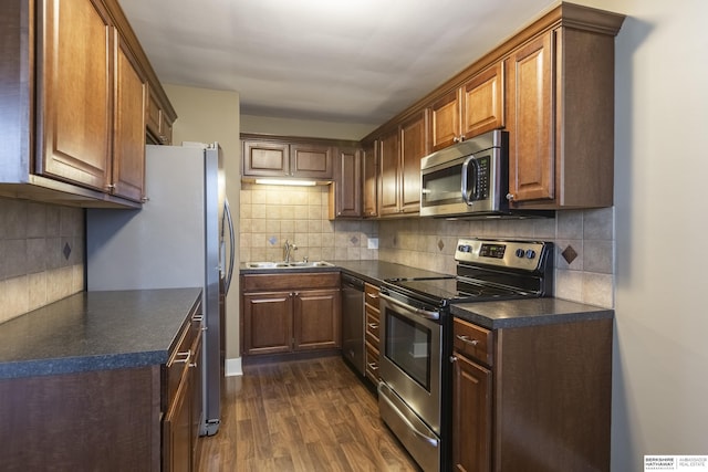 kitchen with sink, stainless steel appliances, dark hardwood / wood-style flooring, and backsplash