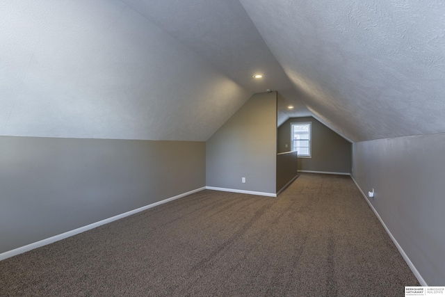 bonus room with lofted ceiling, a textured ceiling, and carpet