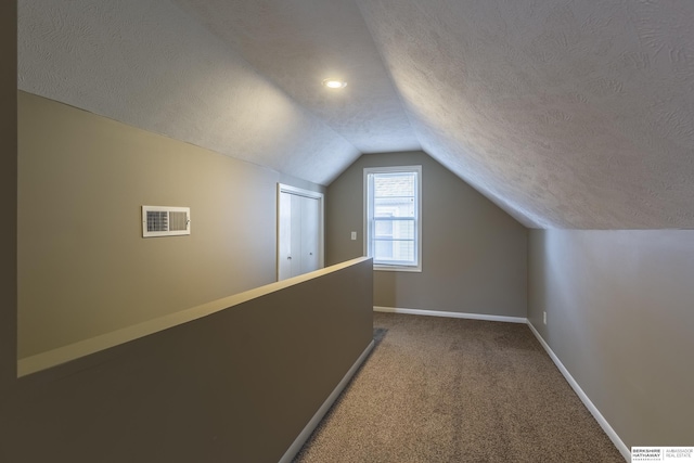 bonus room featuring lofted ceiling, a textured ceiling, and carpet