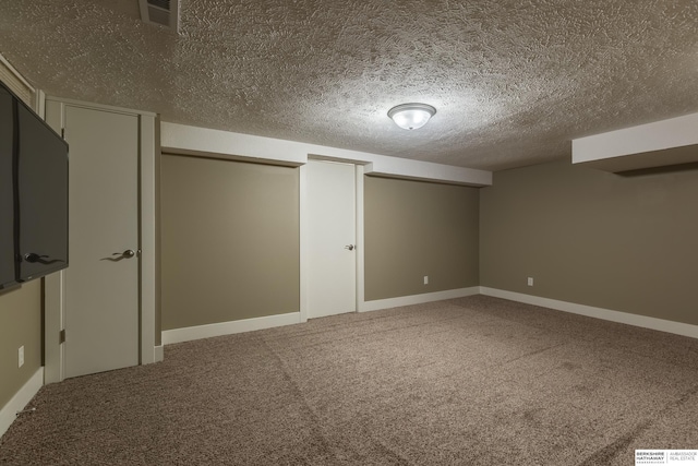 basement featuring a textured ceiling and carpet flooring