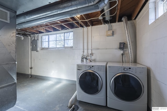 clothes washing area featuring electric panel and washer and dryer