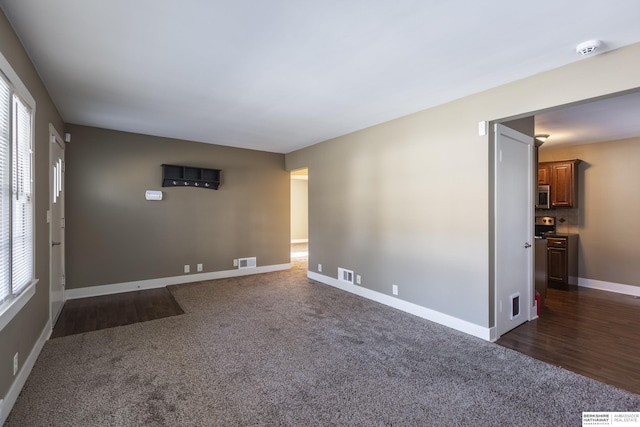 unfurnished room with dark colored carpet