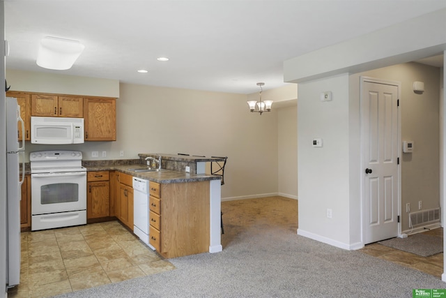 kitchen with kitchen peninsula, light carpet, white appliances, and pendant lighting