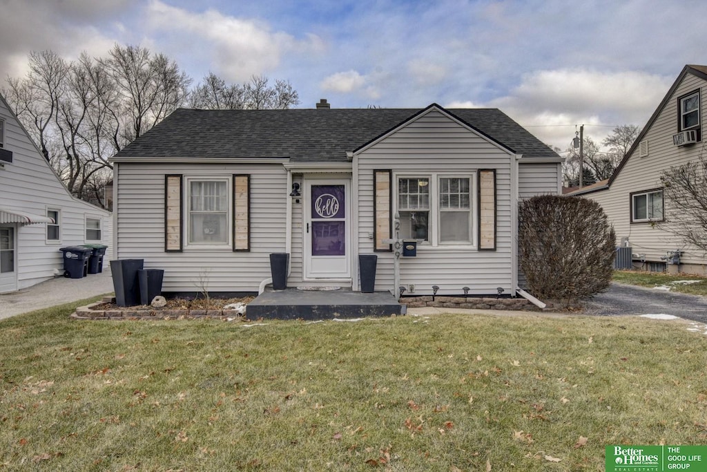 bungalow featuring a front yard, cooling unit, and central air condition unit