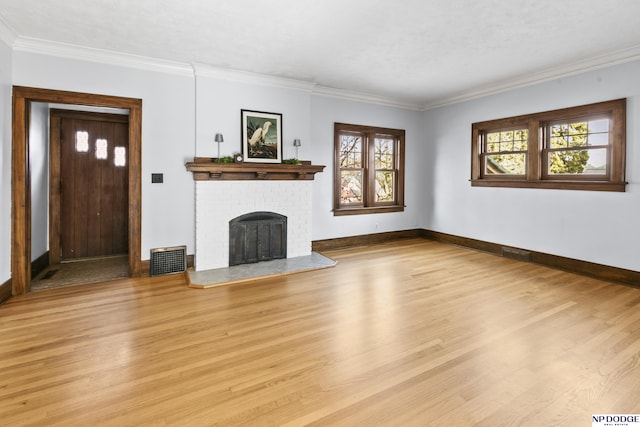 unfurnished living room with ornamental molding, light hardwood / wood-style flooring, and a brick fireplace