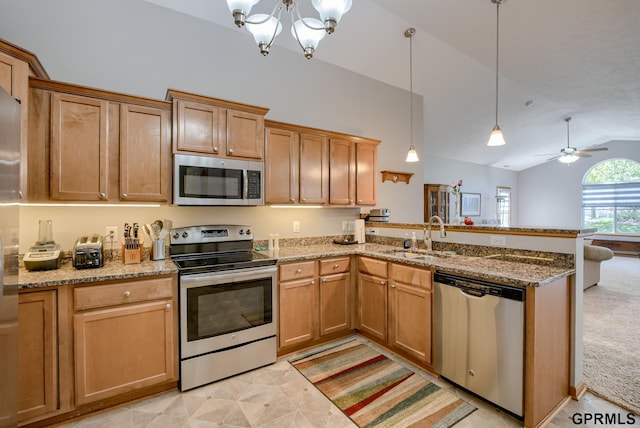 kitchen featuring appliances with stainless steel finishes, decorative light fixtures, vaulted ceiling, ceiling fan with notable chandelier, and sink