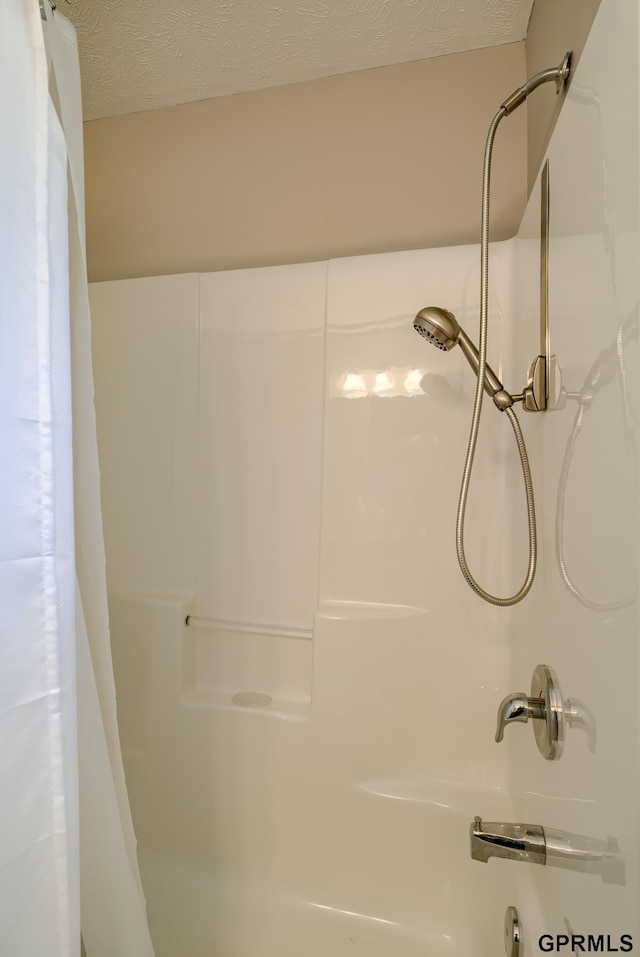 bathroom featuring walk in shower and a textured ceiling