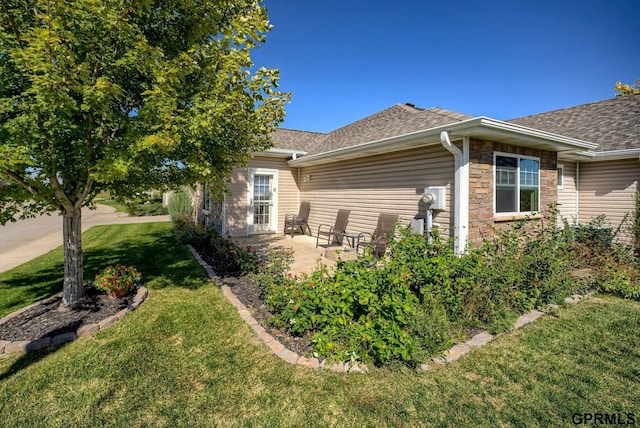 view of side of property featuring a lawn and a patio