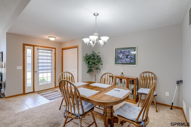 dining room featuring light carpet and a chandelier