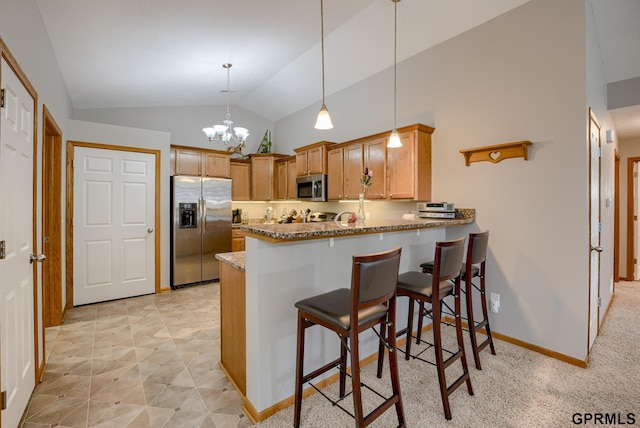 kitchen featuring lofted ceiling, decorative light fixtures, stainless steel appliances, a notable chandelier, and light stone counters