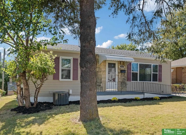 view of front of home featuring central AC unit and a front yard