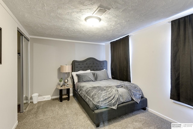 carpeted bedroom with a textured ceiling and ornamental molding