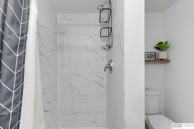 bathroom featuring toilet, a textured ceiling, and a shower with curtain