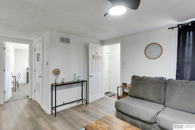 living room featuring a textured ceiling and light hardwood / wood-style flooring