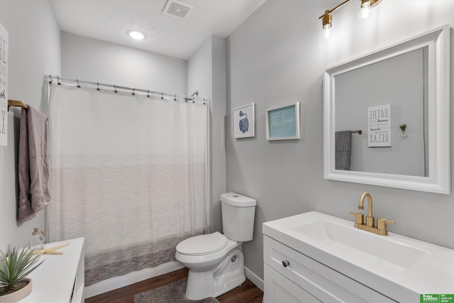 full bathroom with shower / bathtub combination with curtain, hardwood / wood-style floors, vanity, and toilet