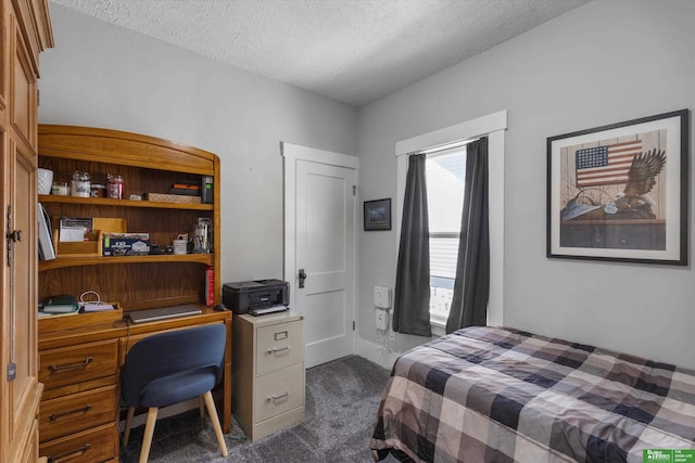 bedroom featuring a textured ceiling and dark carpet