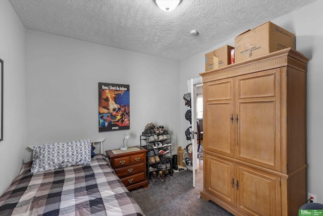 bedroom featuring a textured ceiling and dark carpet