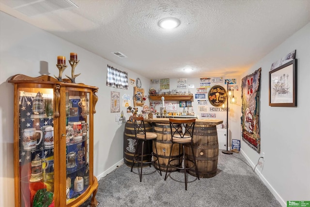 bar featuring a textured ceiling and carpet flooring