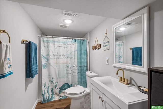 bathroom with a textured ceiling, a shower with shower curtain, hardwood / wood-style flooring, toilet, and vanity