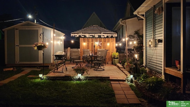 patio at night featuring a storage unit