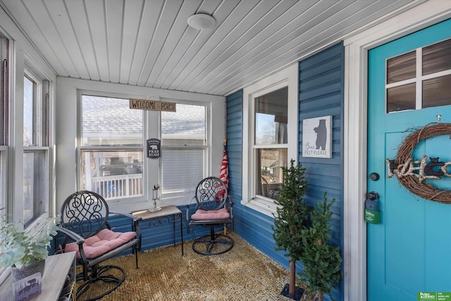 sunroom featuring wood ceiling and plenty of natural light