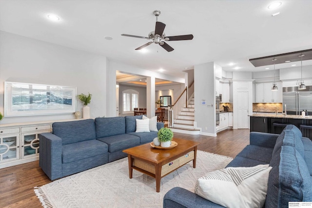 living room featuring ceiling fan and light hardwood / wood-style flooring