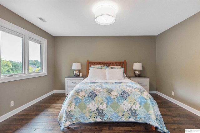 bedroom with dark hardwood / wood-style floors