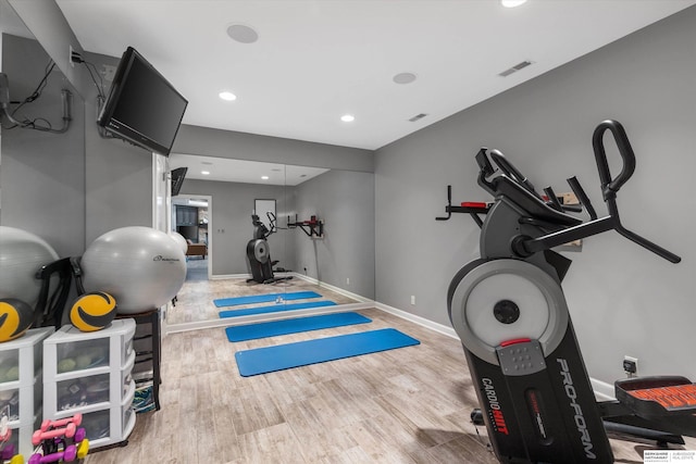 exercise room featuring light wood-type flooring