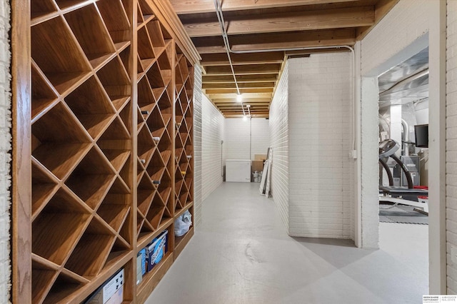 wine area with concrete flooring and brick wall