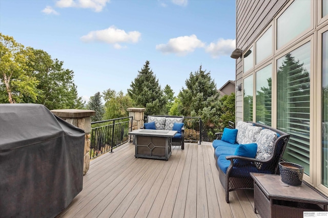 wooden terrace with a grill and an outdoor living space with a fire pit