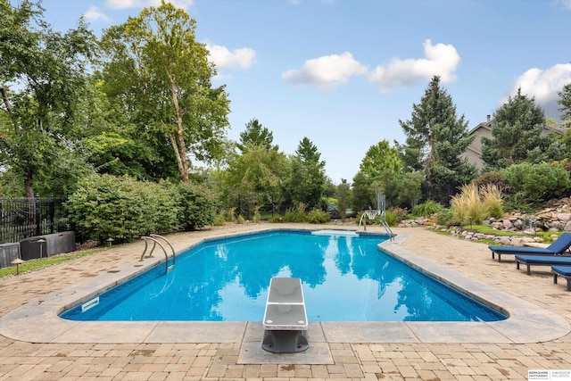 view of pool featuring a diving board and a patio area