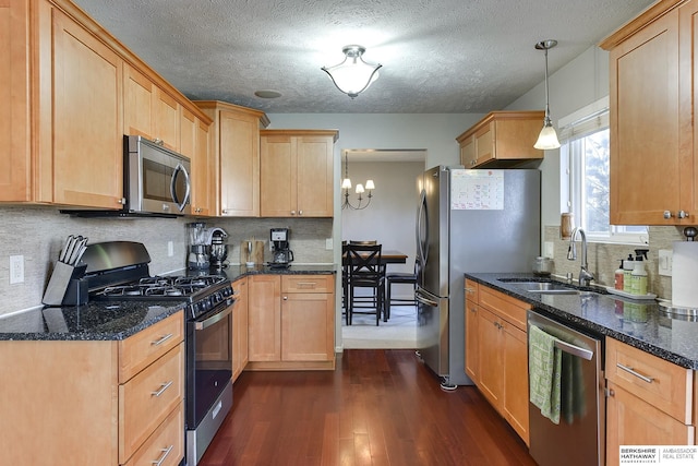 kitchen featuring sink, hanging light fixtures, stainless steel appliances, dark hardwood / wood-style flooring, and backsplash