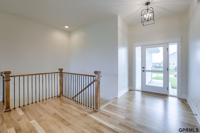 foyer entrance featuring light wood-type flooring and a chandelier