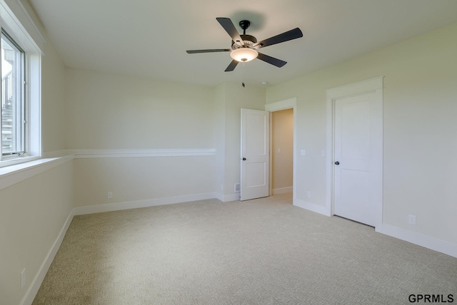 spare room with light carpet and ceiling fan