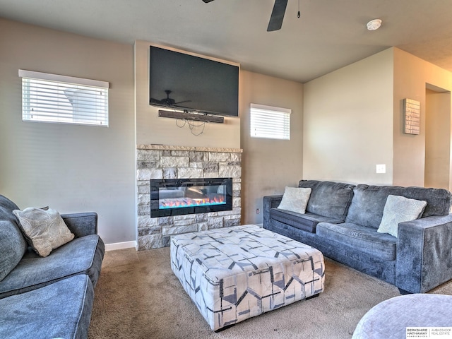 living room with carpet flooring, a stone fireplace, and ceiling fan