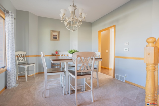 carpeted dining area featuring a chandelier