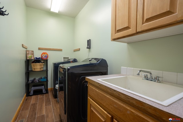 laundry area with washer and clothes dryer, cabinets, and sink