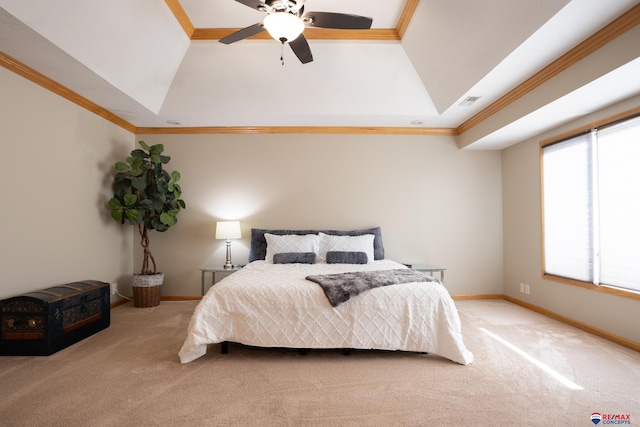 carpeted bedroom with a raised ceiling, ceiling fan, and crown molding