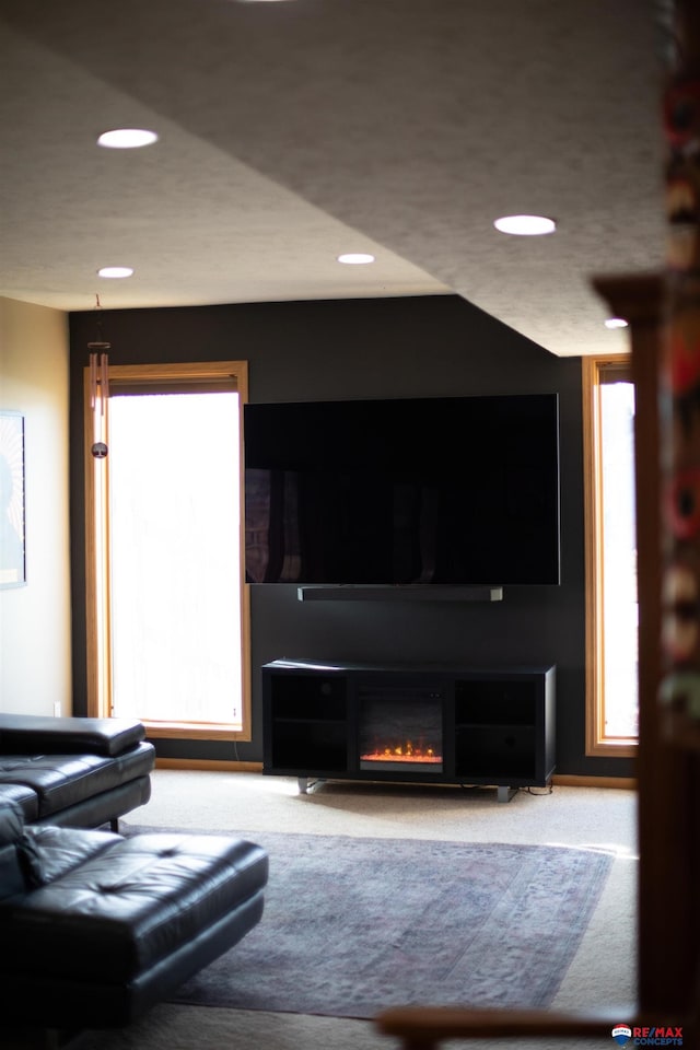 carpeted living room featuring a fireplace and a wealth of natural light