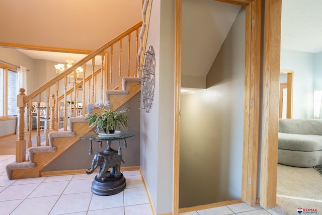 stairs with tile patterned flooring, a chandelier, and lofted ceiling