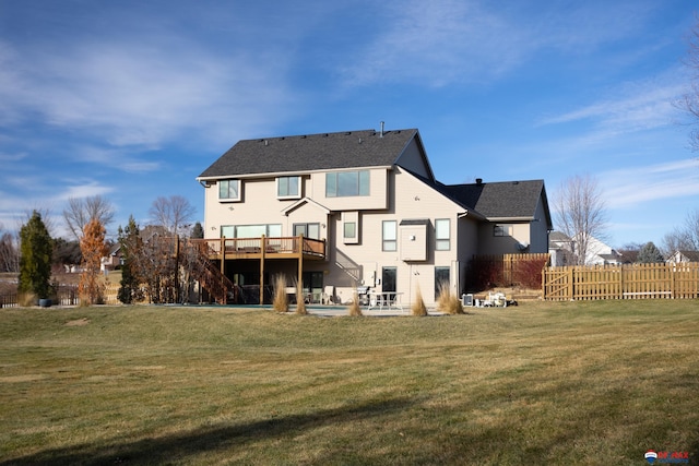 rear view of property featuring a yard and a wooden deck